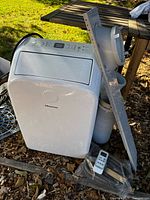 Front view of Hisense portable air conditioner with hose, window kit pieces and remote