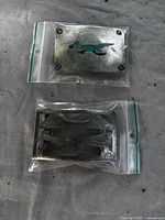 Front view of shark design buckle and reverse of wave design buckle