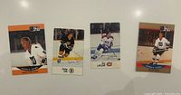 All four hockey trading cards laid out on white surface