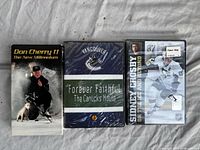 Front covers of three hockey DVDs: Don Cherry 11, Vancouver Canucks Forever Faithful, Sidney Crosby On the Ice and Beyond