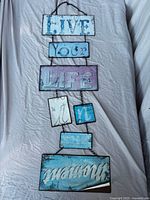 Front view of the hanging sign showing all six linked panels and text