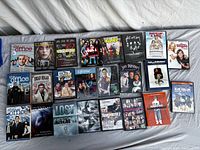 Overall view of 24 DVD cases laid out on bed