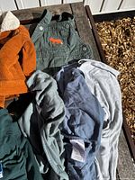 Selection of baby overalls, swaddles, sleepers under sunlight