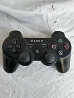 Front view of black Sony DualShock 3 controller showing buttons and sticks