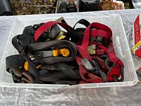 Top view of clear tote showing multiple ratchet straps in various colors and ratchet mechanisms