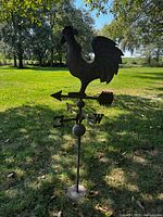 Full view of metal rooster weather vane outdoors