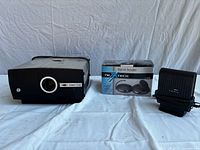 Front view of Sawyer’s Rotomatic 707Q projector beside neXtech signal sender box and Ariza device