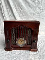Front view showing wood cabinet, grille, tuning dial, control knobs