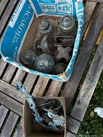 Both boxes showing glass and porcelain insulators and metal bracket with bell