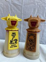 Front view of both plastic cow creamers showing graphics and colors