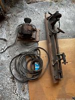 Lathe bed, tool rest, tailstock, separate motor, long power cord on concrete floor