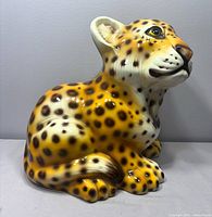 Front left view of ceramic leopard cub figurine