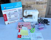 Complete lot with sewing machine, box and accessories laid out