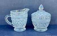 Creamer and covered sugar bowl side by side