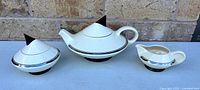 Front view of teapot, sugar bowl and creamer showing complete set and design details