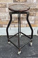 Stool full view front angle showing seat, legs, casters