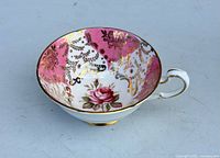 Top view showing interior pink/white panels, gold filigree, central rose