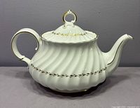 Right side view of Royal Doulton Adrian teapot showing embossed swirl body and gold laurel band