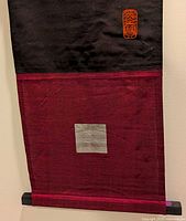 Lower portion showing burgundy fabric texture, silver square accent and bottom dowel