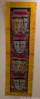 Full view of one batik wall hanging showing entire design and yellow border