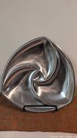 Front view of triangular swirl stainless steel dish