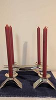 Two WMF Ikora silver-plated candle holders set up with four red taper candles, front view