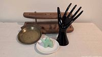 All four items grouped: wood valet tray, brass dish, black hand stand, ceramic elephant holder