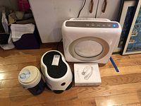 All four items grouped: air purifier, neck fan box, step stool, beverage jug