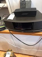 Bose Wave SoundTouch unit with portable speaker and remotes visible