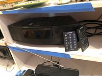 Full view of Bose Wave Radio/CD unit with two remotes in front