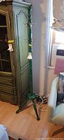 Full view of green coat rack beside cabinet
