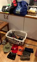 Group view of hats, small bags, laundry basket with shoes, tote bags on cabinet