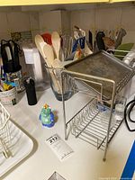 Countertop view showing utensils, rack, dinosaur shaker