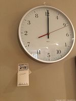 Clock hanging on wall showing entire face and frame