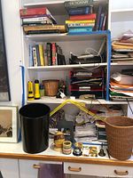 Books, flashlights, baskets, cords on shelving