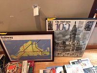 Both framed poster prints leaning against wall