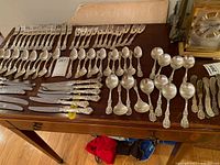 Full layout of flatware set on table showing quantity and variety of pieces