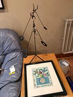 Metal sculpture and framed art on side table