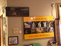 Poster with yellow border and collage of classical artworks mounted on wall