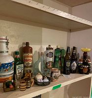 Overview of shelf with assorted bottles, cans and barware