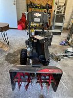 Front and side view of Briggs & Stratton S1024 snow blower showing overall condition, control panel and wheels