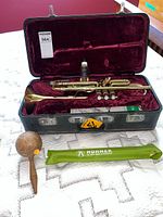 Cornet in open case, maraca, recorder in sleeve visible