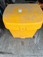 Front top view of FCMP Outdoor yellow grit bin showing overall form and lot sticker