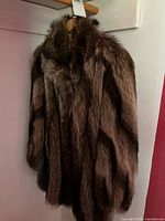 Full view of brown real-fur coat on hanger