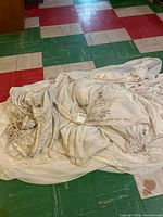 Folded white parachute canopy with shroud lines visible on colored tile floor
