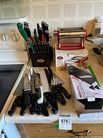 Overall view showing knife block with knives, loose knives, pasta machine on box