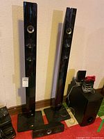 Front view of two LG tower speakers, centre speaker, LG subwoofer and Samsung Blu-Ray player with cables