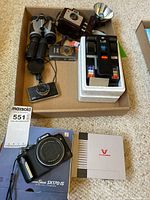Overview of all items in box: cameras, binoculars, splicer, Canon box