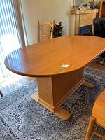 Full view of oak oval dining table top and pedestal base