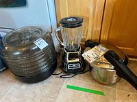 All three appliances grouped together: dehydrator, Oster blender, Presto pressure cooker